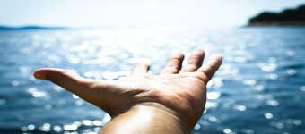 Welcoming Open Hand Above Shimmering Sea