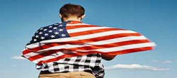 Man Holds USA Flag Against Blue Sky